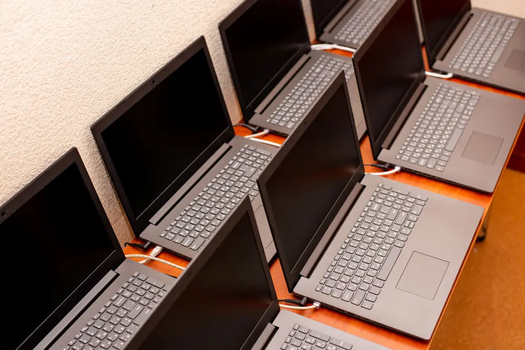 A table with 8 laptop computers.